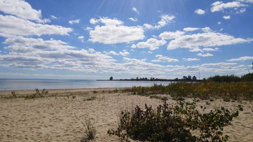 Scenic view of beach against cloudy sky