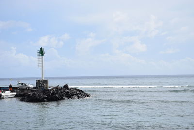 Lighthouse by sea against sky