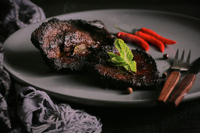 Close-up of steak meal served in plate with red chilies and some nice decoration 