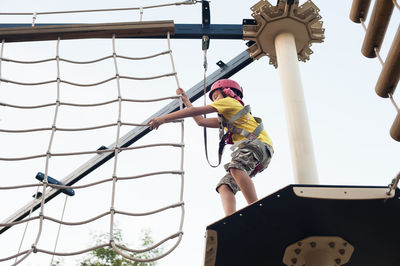 Low angle view of man holding umbrella against sky