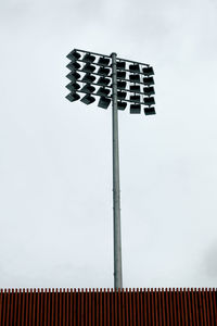 Low angle view of lighting equipment at stadium against clear sky