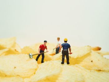 Close-up of figurines on potato chips against white background