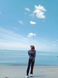 Full length of man standing on beach against sky