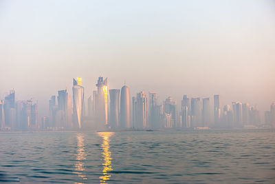 Panoramic view of city buildings against sky during sunset