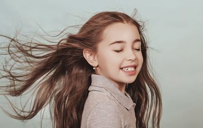 Close-up of smiling young woman against white background