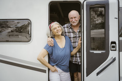 Portrait of smiling couple standing in train