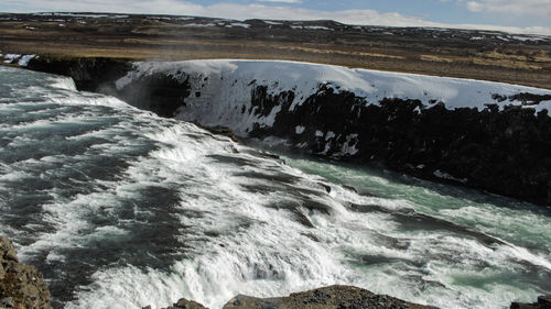 Scenic view of waterfall at sea