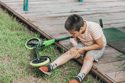 First bandage, child's initiation in world of first-aid, showing determination and care