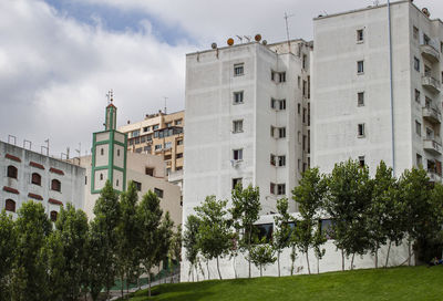 Low angle view of trees and building against sky