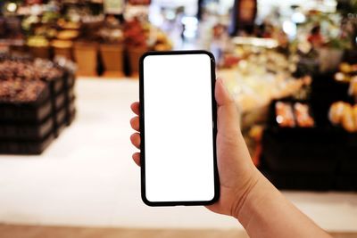 Cropped hands using mobile phone on table