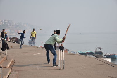 People on beach against clear sky