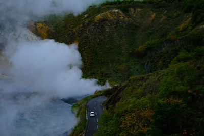 Aerial view of winding road on mountain during foggy weather