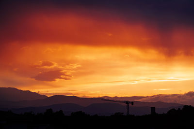 Scenic view of silhouette mountains against orange sky