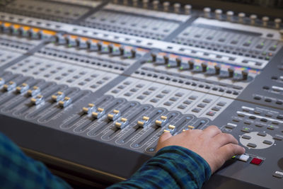 Cropped hand of musician adjusting sound mixer