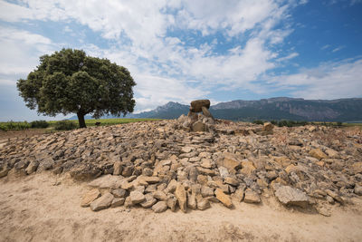 View of rocks on landscape against sky