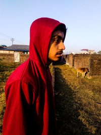 Side view of man standing in farm against sky