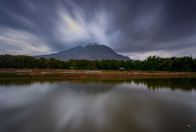 Scenic view of lake by mountains against sky