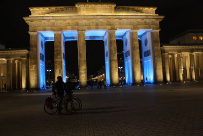 Full length of man on illuminated road in city at night