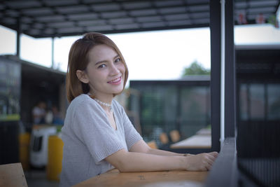 Portrait of woman smiling while sitting at table