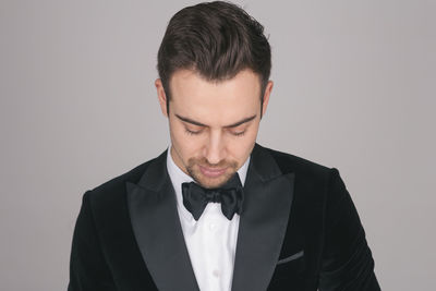 Portrait of young man standing against white background