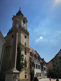 Low angle view of clock tower amidst buildings against sky