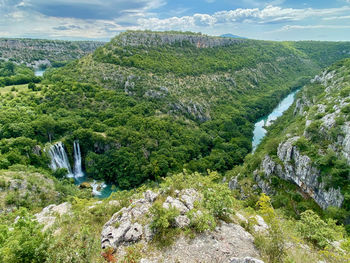 Scenic view of waterfall against sky