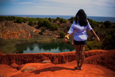 Rear view of woman looking at sea against sky