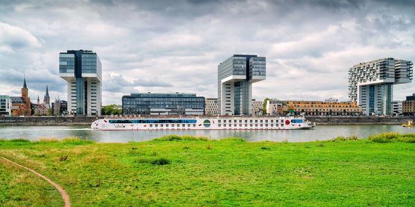 City at waterfront against cloudy sky