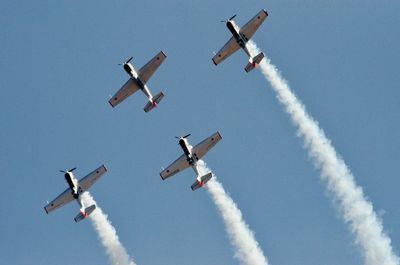 Low angle view of airshow against clear sky