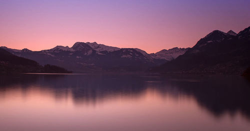 Scenic view of lake and mountains against romantic sky