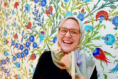 Portrait of smiling woman against tiled wall