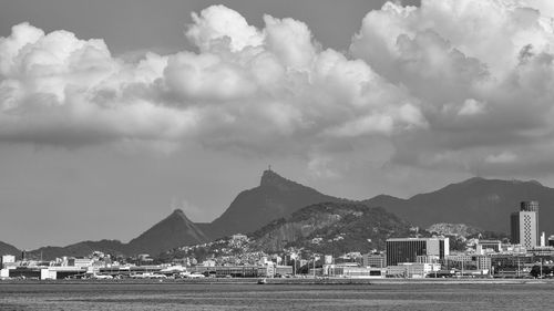 Panoramic view of buildings by mountains against sky