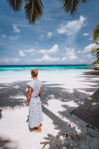 Rear view of woman standing at beach