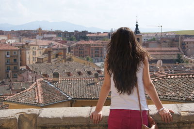 Rear view of woman looking at townscape against sky