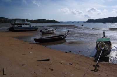 Boats moored on beach against sky