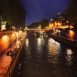 Illuminated bridge over river at night