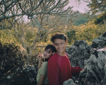 Portrait of young couple against trees