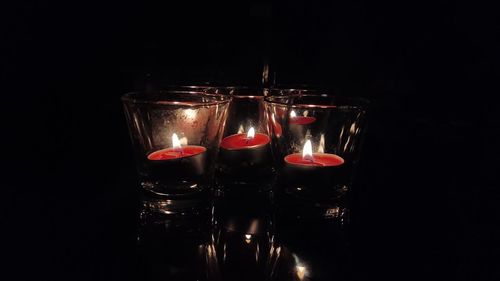 Close-up of lit candles in darkroom