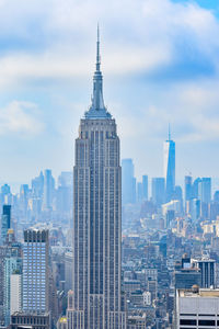 Modern buildings in city against cloudy sky