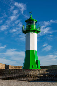 Low angle view of lighthouse against building against sky