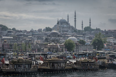 High angle view of cityscape against cloudy sky during sunny day