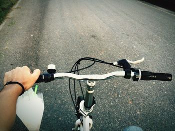 Cropped hand of man riding bicycle on street