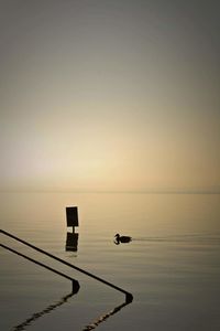 Scenic view of lake against sky at sunset