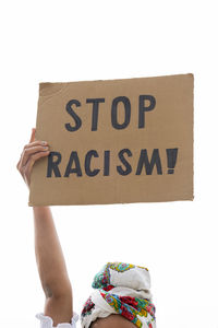 Low section of person holding paper against white background