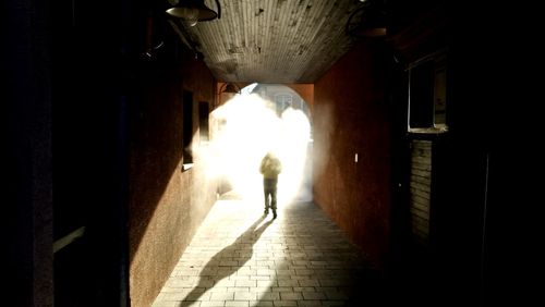 Rear view of man and woman walking in tunnel