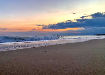 Scenic view of beach against sky during sunset