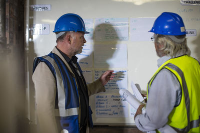 Construction worker and engineer discussing project in site office