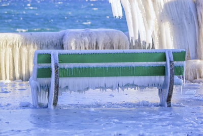 One frozen bench and lakeside near geneva lake, versoix, switzerland 