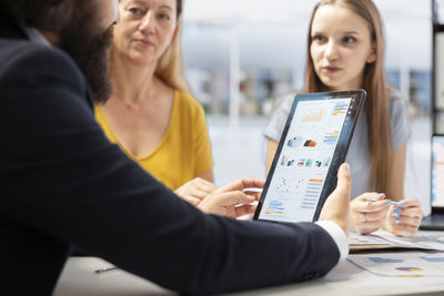 Midsection of woman using digital tablet in office