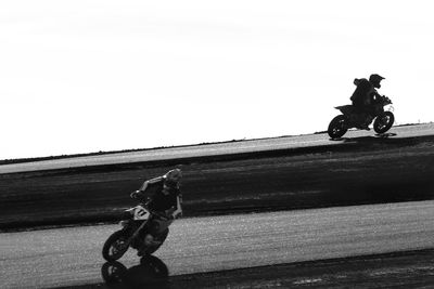 Man riding bicycle on motorcycle against sky